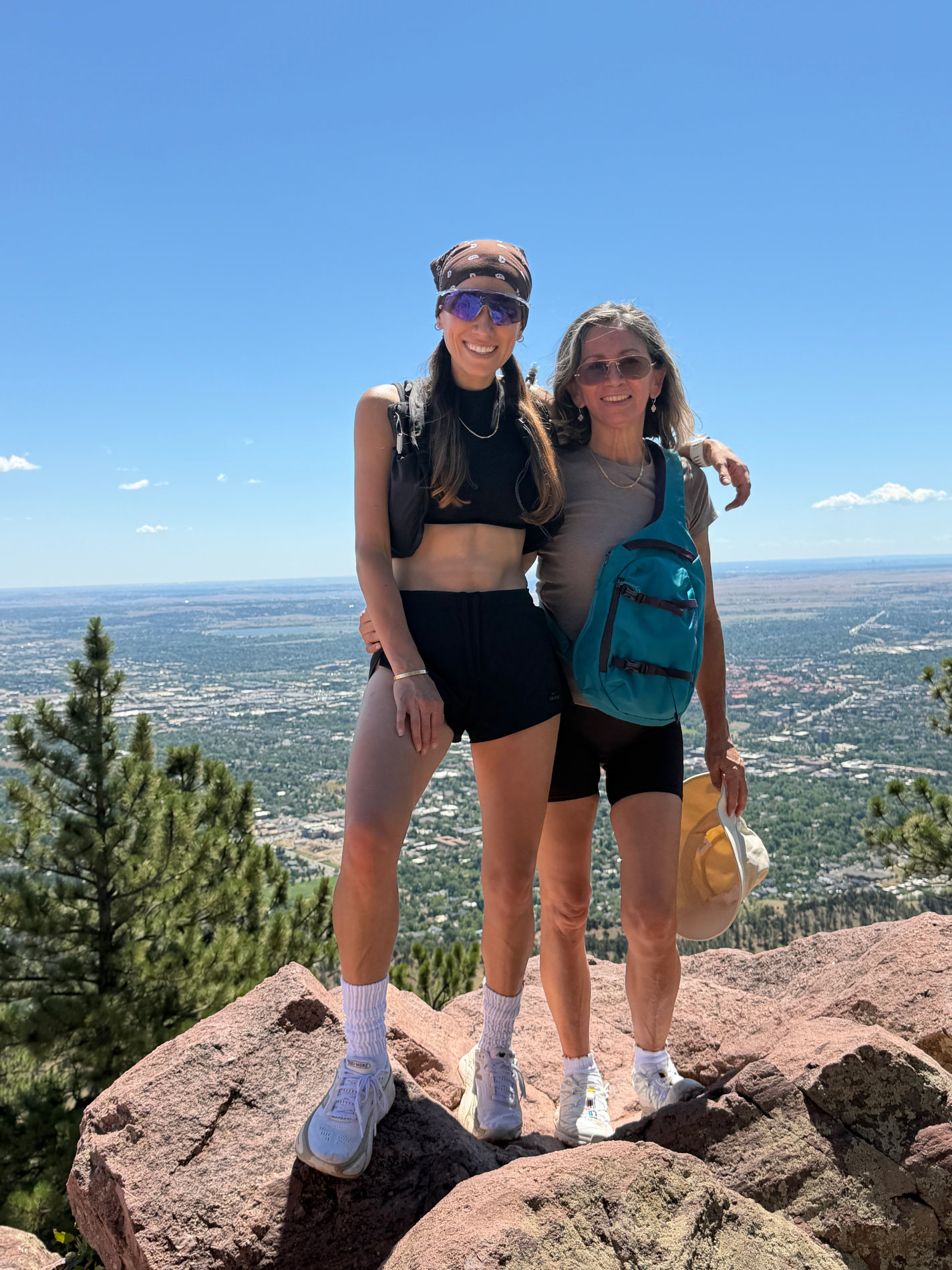 Mamá y su hija abrazadas en lo alto de una montaña